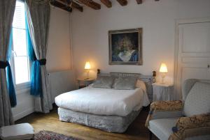 um quarto com uma cama, um sofá e uma cadeira em B&B La Closeraie em Vouvray
