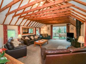 a living room with leather furniture and a wooden ceiling at Travellers Rest in Minehead