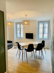 uma sala de jantar com mesa e cadeiras em Suite 24 Appart'hôtel-L'Annexe-3 étoiles em Montceau-les-Mines