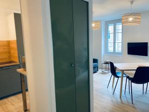 une porte verte dans une pièce avec une table dans l'établissement Suite 24 Appart'hôtel-L'Annexe-3 étoiles, à Montceau-les-Mines