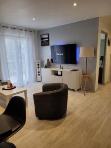 a living room with a couch and a tv at L èphéjules in Marseillan