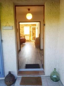 een open deur naar een woonkamer met twee vazen bij L'agréable maison du Verdon in Gréoux-les-Bains