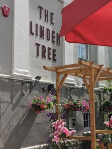 ein Schild für einen Holzbaum vor einem Gebäude in der Unterkunft Linden Tree in Gloucester