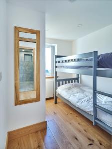 a bedroom with two bunk beds and a mirror at White Watch in Lochaline