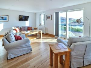 a living room with two chairs and a table at White Watch in Lochaline +14 photos
