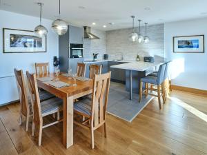 a kitchen and dining room with a wooden table and chairs at White Watch in Lochaline