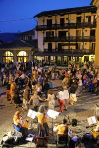 un grande gruppo di persone sedute di fronte a un edificio di Albergo Miniere a Traversella