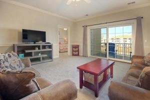 a living room with couches and a tv and a table at Myrtle Magic in Myrtle Beach