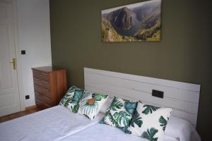 - une chambre dotée d'un lit avec des oreillers et une photo sur le mur dans l'établissement Albareda piso super-céntrico en Sarria, à Sarria