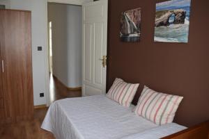 - une chambre avec un lit et deux oreillers dans l'établissement Albareda piso super-céntrico en Sarria, à Sarria