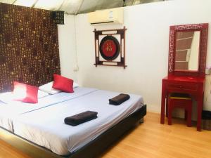 una camera da letto con un letto con cuscini rossi e uno specchio di The Natural Yurt Resort @ Khao Kho a Khao Kho