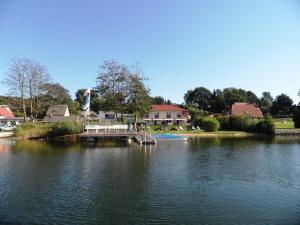 un muelle en un lago con un barco en él en Ferienwohnungen direkt am See bei den Kaiserbädern en Heringsdorf