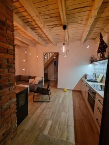 eine offene Küche und ein Wohnzimmer mit einer Ziegelwand in der Unterkunft Na Hamaku Jacuzzi & Sauna in Marzysz