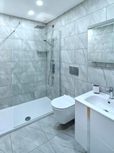 y baño con aseo, lavabo y ducha. en Red Watch Apartment, en Oban