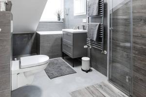e bagno con servizi igienici, lavandino e doccia. di Exklusive (DG) Neubau-Ferienwohnung mit Fernsicht a Costanza