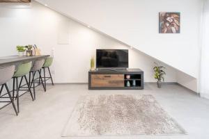ein Wohnzimmer mit einem TV und einem Tisch in der Unterkunft Exklusive (DG) Neubau-Ferienwohnung mit Fernsicht in Konstanz