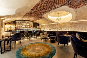 a restaurant with a bar with chairs and a large rug at Hôtel Roi de Sicile - Rivoli in Paris