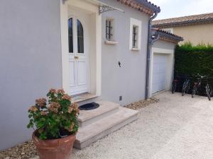 ein weißes Haus mit einer weißen Tür und einer Topfpflanze in der Unterkunft Villa accueillante à Colonzelle avec piscine privée in Colonzelle
