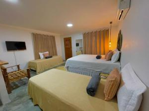 a hotel room with two beds and a couch at Pousada Monte das Serras in Serra de São Bento +50 photos