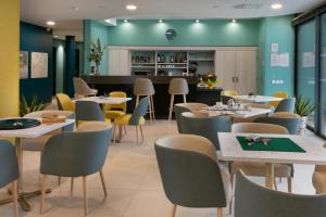 un restaurante con mesas y sillas y un bar en DOMITYS BASALTIK en Agde