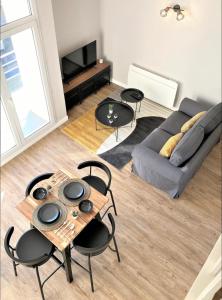 a living room with a couch and a table and chairs at Sacré cœur - Duplex avec balcon - 4 pers in Cholet