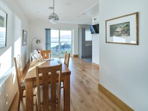 comedor y cocina con mesa de madera y sillas en Blue Watch en Lochaline
