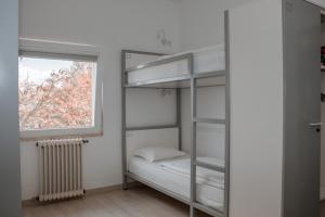 HI Viseu - Pousada de Juventude في فيزيو: غرفة نوم مع سرير بطابقين ونافذة