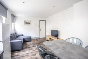 a living room with a couch and a tv at Le Saint Louis in Périgueux