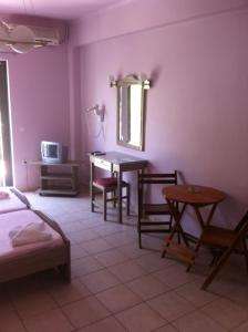Amalia Hotel في كالوغريا: غرفة نوم مع طاولة وكراسي ومكتب