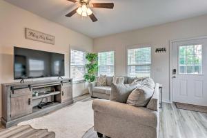 a living room with a couch and a flat screen tv at Idyllic Pensacola Home with Yard and Fire Pit! in Pensacola