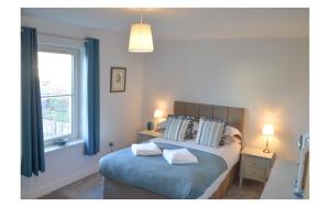 a bedroom with a bed with pillows and a window at COASTAL COTTAGE ideal for golf, walking and cycling in Kingsbarns
