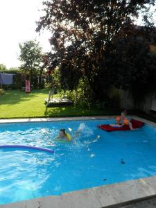 dos niños jugando en una piscina en Csiki Apartman, en Budaörs