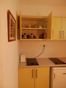 a kitchen with yellow cabinets and a counter top at Csiki Apartman in Budaörs