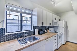 a white kitchen with a sink and a refrigerator at Trendy Getaway with Patio Near Roosevelt Row! in Phoenix