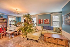 a living room with a christmas tree and a piano at Vintage Farmhouse Near Sunday River Ski Slopes! in Rumford