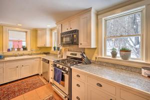 uma cozinha com armários brancos e um forno com placa de fogão em Vintage Farmhouse Near Sunday River Ski Slopes! em Rumford