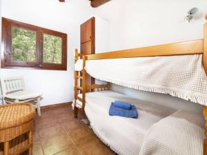 ein Schlafzimmer mit einem Etagenbett und einem Stuhl in der Unterkunft Casa Rustica con piscina en Girona in Fornells de la Selva