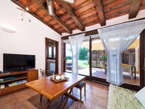 sala de estar con mesa y TV en Casa Rustica con piscina en Girona en Fornells de la Selva