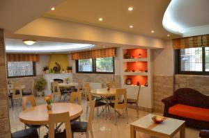 a restaurant with tables and chairs and windows at Elli Maria in Limenas