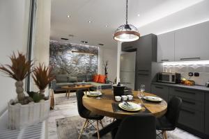 a kitchen and living room with a table and chairs at LA Larissa Luxury Apartments Kreousa in Larisa