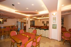 een restaurant met een tafel en stoelen en een bar bij Семеен Хотел Елена Палас in Nesebar
