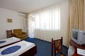 a hotel room with two beds and a television at Семеен Хотел Елена Палас in Nesebar +38 photos