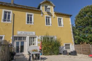 une maison jaune avec une table devant elle dans l'établissement La Saucisserie Gites, à Saint-Pierre-de-Frugie