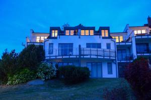 a large white house with its lights on at Larus Appartment Residenz Bellevue WG 5 in Zinnowitz