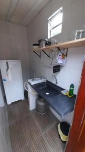a small kitchen with a sink and a stove at Cantinho HAKUNA MATATA-Vale do Capão a 5 min da Vila in Vale do Capao