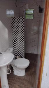 a bathroom with a white toilet and a sink at Cantinho HAKUNA MATATA-Vale do Capão a 5 min da Vila in Vale do Capao