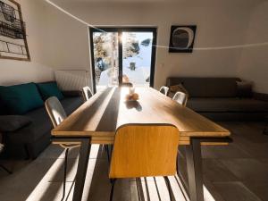 een houten tafel in een woonkamer met stoelen bij Sunshine Apartments Golte COMFORT in Mozirje