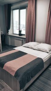 Un pat sau paturi într-o cameră la Гостиница На Набережной