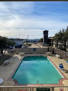 ein großer Pool mit einem Uhrturm im Hintergrund in der Unterkunft La Quinta Inn by Wyndham Tyler in Tyler