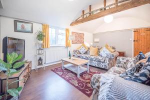 a living room with a couch and a table at Suncatch Corner, Saxmundham in Saxmundham